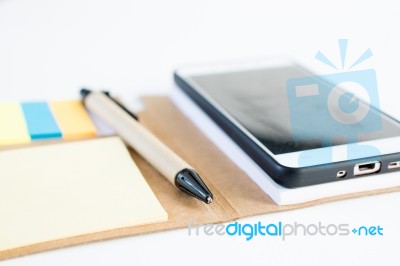 Mobile Phone Notebook And Pen On White Background Stock Photo