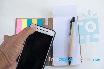 Mobile Phone Notebook And Pen On White Background Stock Photo