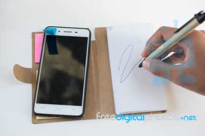 Mobile Phone Notebook And Pen On White Background Stock Photo