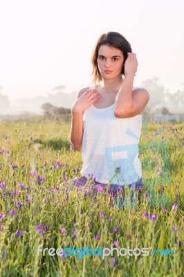 Model Sitting In Field Stock Photo