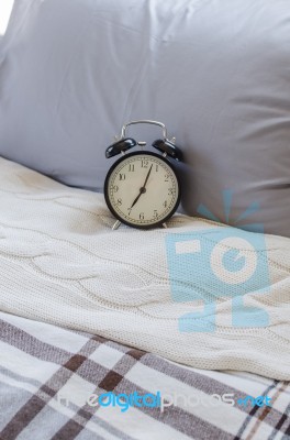 Modern Black Alarm Clock On Bed Stock Photo