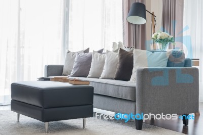 Modern Grey Sofa With Pillows And Black Table In Living Room Stock Photo