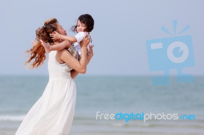 Mom And Son Play On Beach Stock Photo