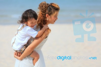 Mom And Son Play On Beach Stock Photo