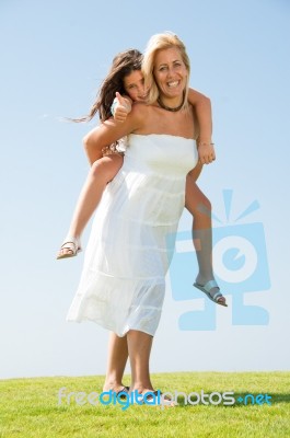 mom Giving Piggyback Ride Stock Photo