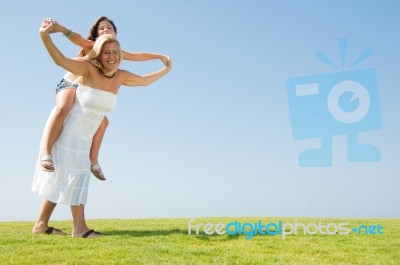 mom Giving Piggyback Ride Stock Photo