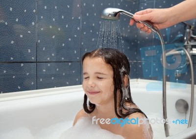 Mom Pours A Little Girl Out Of The Shower Stock Photo