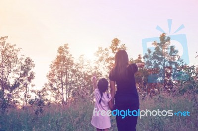 Mother And Daughter On Sunset Watching On Sky Stock Photo