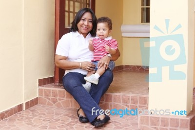 Mother And Son Outside Of Their New House.  Focus On The Baby Stock Photo