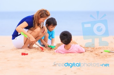 Mother And Sons Are Playing On Tropical Beach Stock Photo