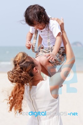 Mother Holding Son On Beach Stock Photo