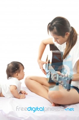 Mother Is Playing A Guitar For Her Baby Stock Photo