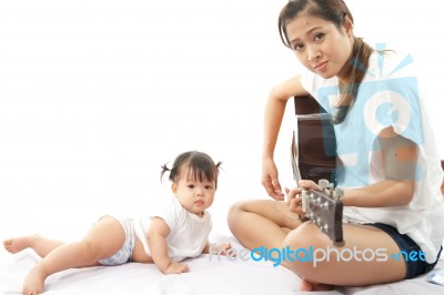 Mother Is Playing A Guitar For Her Baby Stock Photo