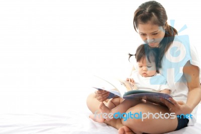 Mother Is Reading A Book For Her Baby Stock Photo