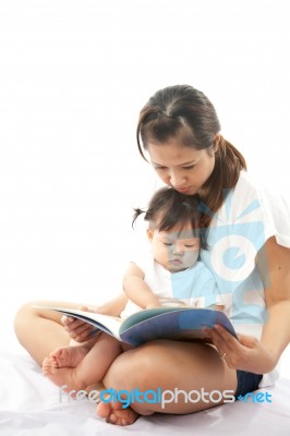 Mother Is Reading A Book For Her Baby Stock Photo