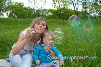 Mother With Her Son Blow Bubbles Stock Photo