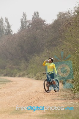 Mountain Bicycle Man Drinking Fresh Water From Bottle On Dirt Track Stock Photo