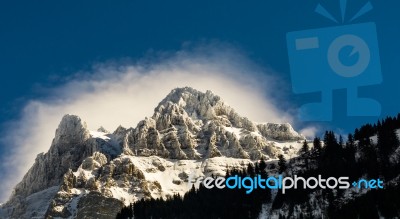 Mountain Peak With A Halo Of Cloud Cover Stock Photo