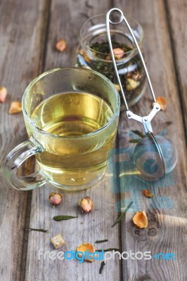 Mug Of Flavored Green Tea With Rose Buds And Petals Stock Photo