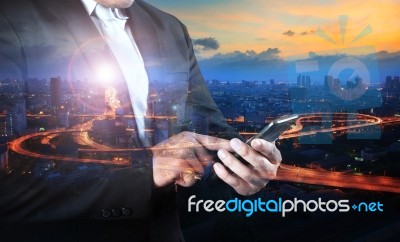 Multi Exposure Business Man And Traffic In Town Touching On Smart Phone Using For Internet Network Technology In E-commerce, Digital Lifestyle Stock Photo