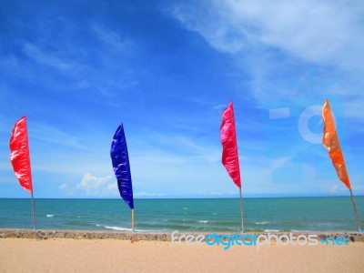 Multicolored Flag On The Beach With Blue Sky And Blue Sea Stock Photo