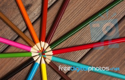 Multicolored Pencils On A Background Of Dark Wood Tables Stock Photo