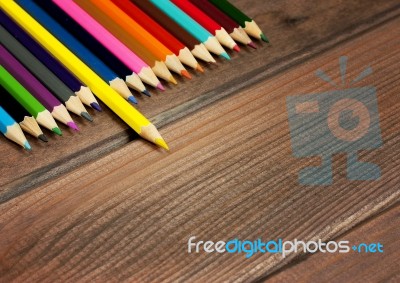 Multicolored Pencils On A Background Of Dark Wood Tables Stock Photo