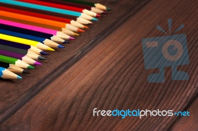 Multicolored Pencils On A Background Of Dark Wood Tables Stock Photo