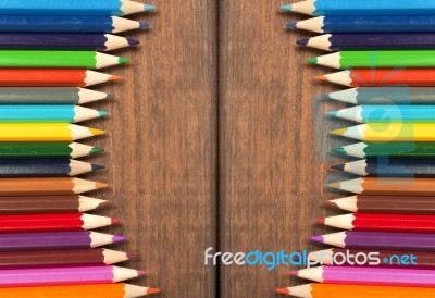 Multicolored Pencils On A Background Of Dark Wood Tables Stock Photo