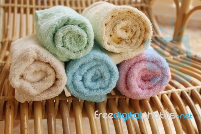 Multicolour Towels Rolls On Wood Chair Stock Photo