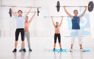 Multiethnic Group Of People Exercising With Weightlifting Bar In… Stock Photo