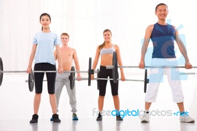 Multiethnic Group Of People Exercising With Weightlifting Bar In… Stock Photo