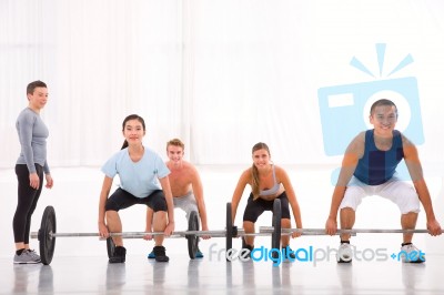 Multiethnic Group With Weightlifting Bar Workout In Fitness Cent… Stock Photo