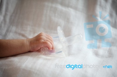 New Born Baby Hand Holding Pacifier Stock Photo