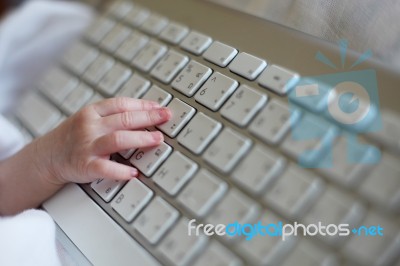 New Born Baby's Hand Using Keyboard Stock Photo