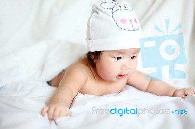 Newborn Baby With Cow Hat Lying Down On A White Blanket Stock Photo