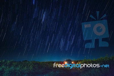 Night Scene Of Star Tail And Blue Sky Over Car Parking In Agriculture Field Stock Photo