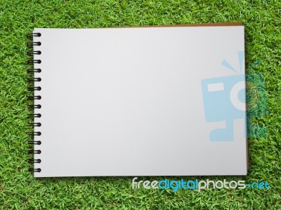 Note Book On Green Grass Stock Photo