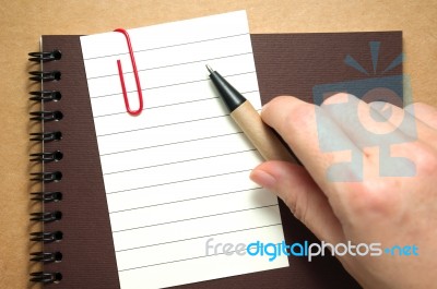 Note Paper With Hand And Pen Stock Photo