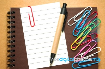 Note Paper With Pen And Paperclips On Notebook Stock Photo