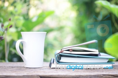 Notebook  And Coffee Cup On Wooden Table Stock Photo