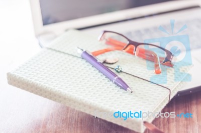 Notebook And Eyeglasses With Computer On Wooden Table Stock Photo