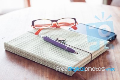 Notebook And Pen With Smartphone On Wooden Table Stock Photo