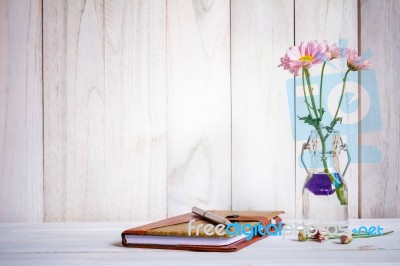 Notebook Or Journal With Pen Of Flowers Arranged On A Neutral White Painted Desk Stock Photo