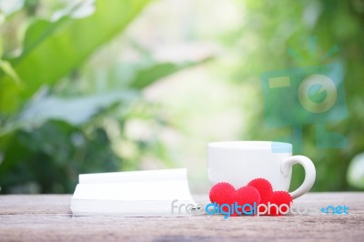 Notepad And Coffee With Heart Decoration On Wooden Table Stock Photo