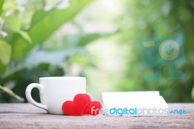 Notepad And Coffee With Heart Decoration On Wooden Table Stock Photo