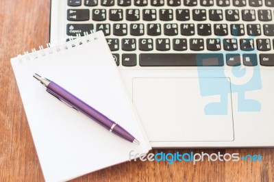 Notepad And Laptop On Wooden Table Stock Photo