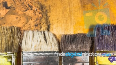 Oil Paint Brushes On Wood Painted Background Stock Photo