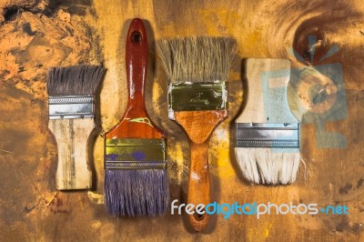 Oil Paint Brushes On Wood Painted Background Stock Photo