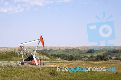 Oil Well In Grassy Field Stock Photo